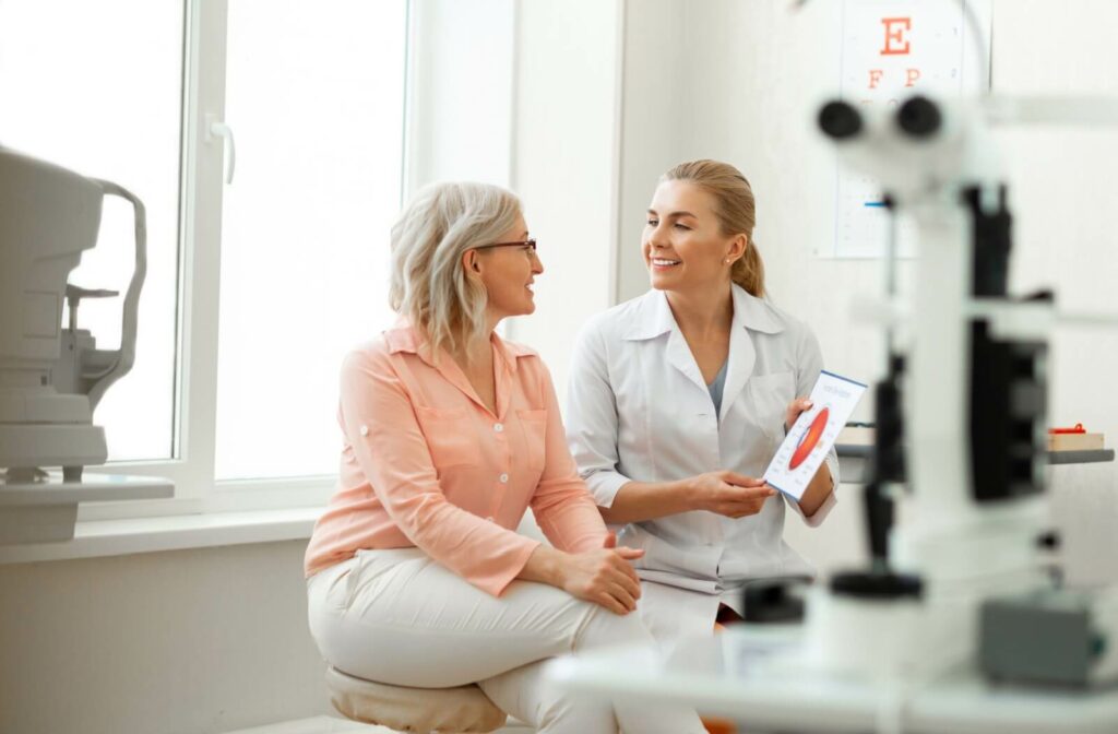 An optometrist showing an older patient a diagram of the eye.