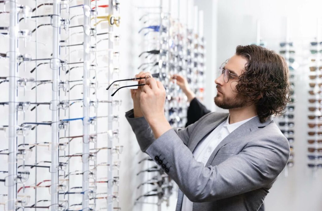 A person browsing and comparing eyeglasses at an eyewear store