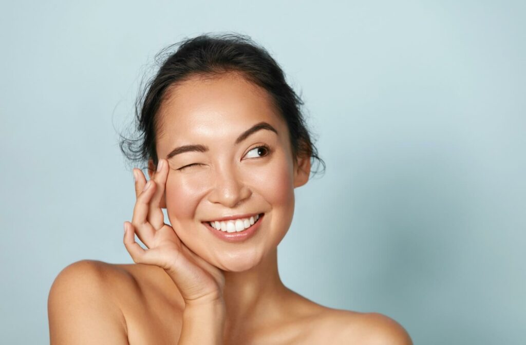 A person smiles and blinks after an IPL treatment, now free of dry eye symptoms.